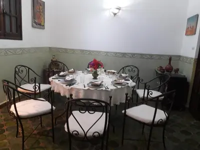 a dining room with a table with chairs and a tableablish at Dar Nakhla Zagora Guest House Restaurant & Desert Excursions in Zagora