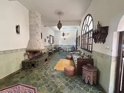 a living room with a large fireplace in a house at Dar Nakhla Zagora Guest House Restaurant & Desert Excursions in Zagora