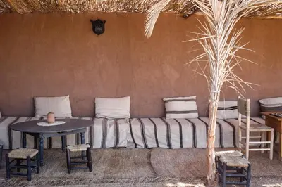 a room with a couch and a table and chairs at Kasbah Aitisfoul in Tagounite