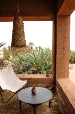 a table and a chair in a room with a window at Kasbah Aitisfoul in Tagounite