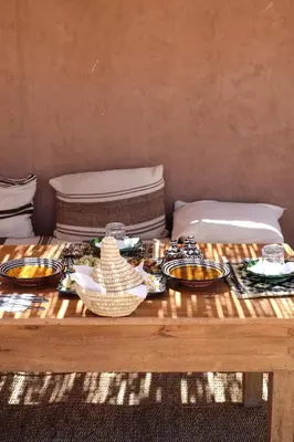 a wooden table with plates of food on it at Kasbah Aitisfoul in Tagounite