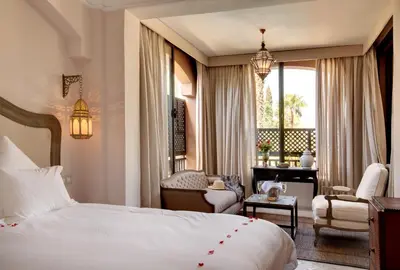 a hotel room with a bed and a chair and a desk at Palais de l'O - Maison d'hôtes in Marrakech