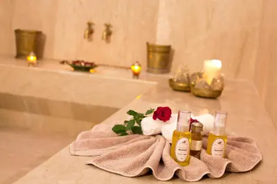 a bathroom counter with two bottles of essential oils and a rose at Palais de l'O - Maison d'hôtes in Marrakech