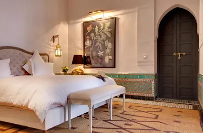 a bedroom with a bed and a black door at Palais de l'O - Maison d'hôtes in Marrakech