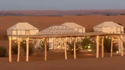 a hotel in the desert at night at Royal Luxury Camp in Merzouga