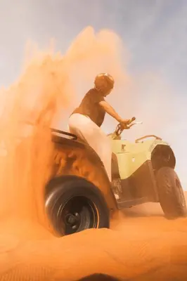 a person riding a quad bike in the sand at Royal Luxury Camp in Merzouga