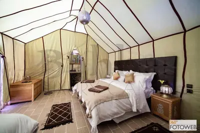 a bedroom with a bed in a tent at Sahara Happy Camp in Merzouga