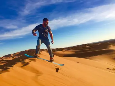 a man on a skateboard in the desert at Sahara Happy Camp in Merzouga