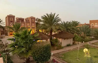 an aerial view of a resort with palm trees and buildings at Sbai Palace in Mhamid