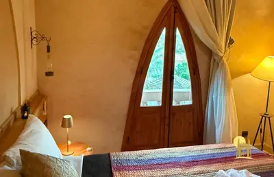 a bedroom with a bed with a window and a door at Sbai Palace in Mhamid