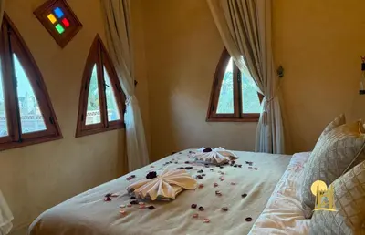 a bedroom with flowers on a bed with windows at Sbai Palace in Mhamid