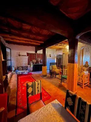 a living room with a table and chairs at Kasbah El Hajja in Aït Ben Haddou