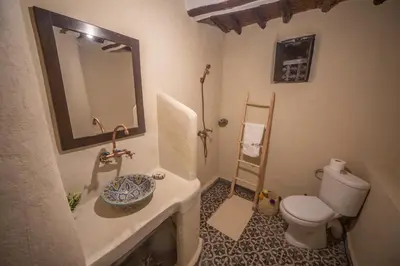 a bathroom with a toilet and a sink and a mirror at Kasbah El Hajja in Aït Ben Haddou