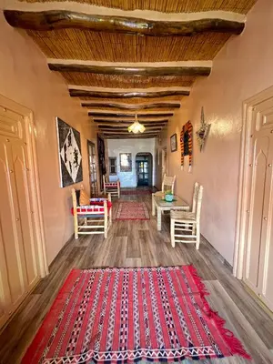 a living room with a red rug on the floor at Kasbah El Hajja in Aït Ben Haddou