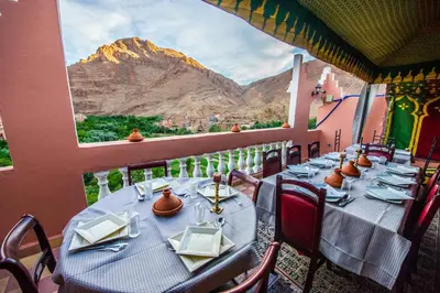 a table on a balcony with a view of a mountain at Riad Sephora in Tinerhir