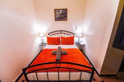 a bedroom with a bed with an orange blanket at Riad Sephora in Tinerhir