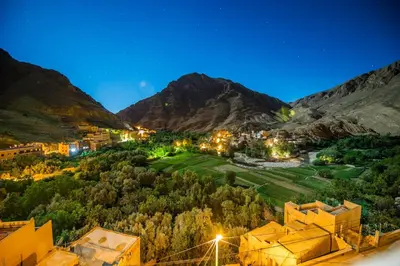 a view of a town in the mountains at night at Riad Sephora in Tinerhir