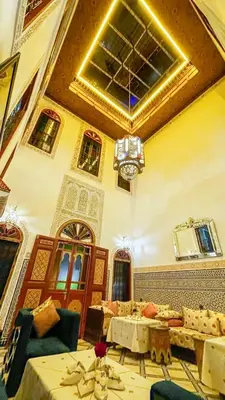 a living room filled with furniture and a ceiling at Riad Dar El Ouedghiri in Fès