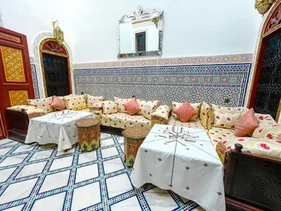 a living room with a couch and tables at Riad Dar El Ouedghiri in Fès