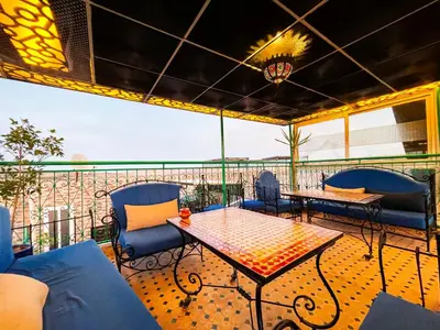 a patio with a table and chairs on a balcony at Riad Dar El Ouedghiri in Fès