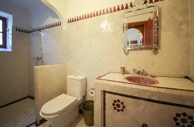 a bathroom with a toilet and a sink and a mirror at Dar Dalila Fes in Fès