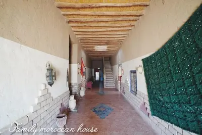 a hallway in a building with a green wall at Sahara Desert Experience camp in Merzouga