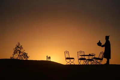 a silhouette of a man standing on a hill at sunset at Sahara Desert Experience camp in Merzouga