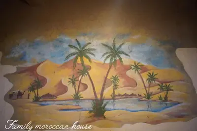 a painting of a desert with palm trees and a mountain at Family Moroccan House in Merzouga