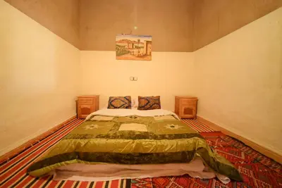 a bedroom with a large bed in a room at Family Moroccan House in Merzouga