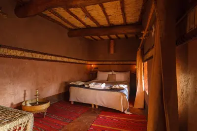 a bedroom with a bed and a tub in a room at Kasbah Tebi in Aït Ben Haddou