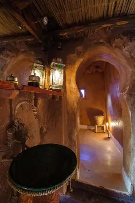 a room with a black table in a stone room at Kasbah Tebi in Aït Ben Haddou
