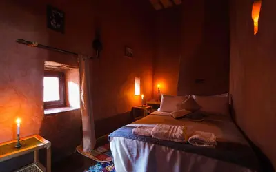 a bedroom with a bed in a room with a window at Kasbah Tebi in Aït Ben Haddou