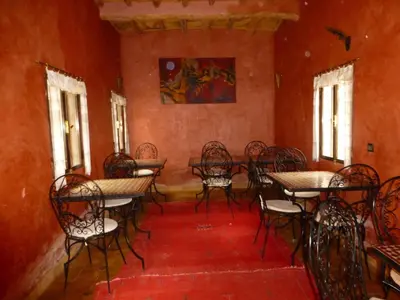 an empty dining room with tables and chairs at Kasbah La Cigogne in Aït Ben Haddou