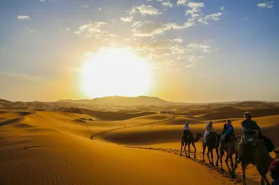 a group of people riding horses in the desert at Sky Luxury Camp in Mhamid