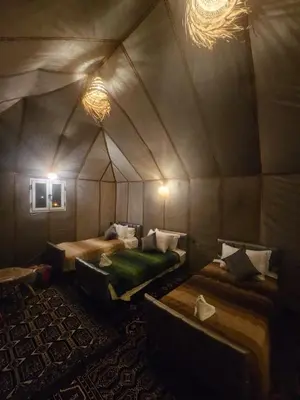 a room with two beds in a tent at Typical Luxury Desert Camp in Merzouga