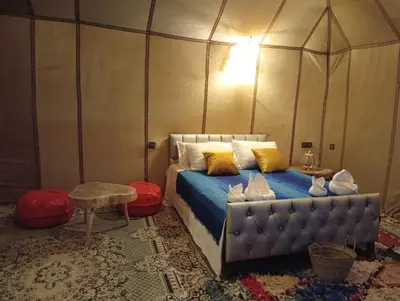 a bedroom with a bed in a tent at Typical Luxury Desert Camp in Merzouga