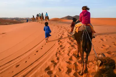a group of people riding horses in the desert at Typical Luxury Desert Camp in Merzouga