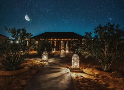 a building with lights in front of it at night at Tassili Luxury Desert Camp in Merzouga