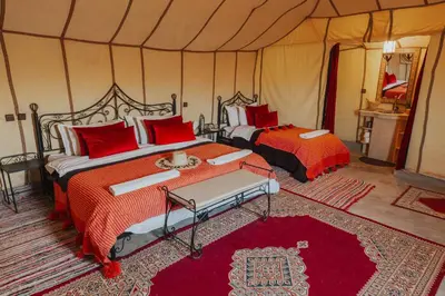 a bedroom with two beds in a tent at Tassili Luxury Desert Camp in Merzouga