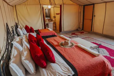 a bedroom with two beds in a tent at Tassili Luxury Desert Camp in Merzouga