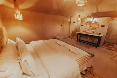 a bedroom with a large bed and a mirror at Tassili Luxury Desert Camp in Merzouga