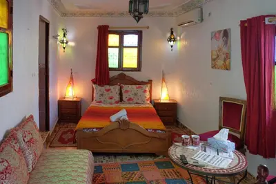 a bedroom with a bed and a couch and a table at Maison Famille Tazi in Fès