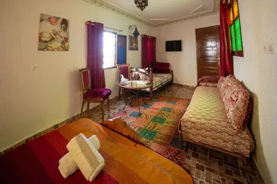 a bedroom with a bed and a table and chairs at Maison Famille Tazi in Fès