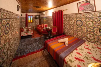 a bedroom with a bed and a table in a room at Maison Famille Tazi in Fès