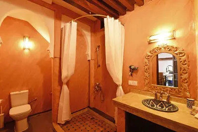 a bathroom with a sink and a toilet and a mirror at Riad Alassala Fes in Fès