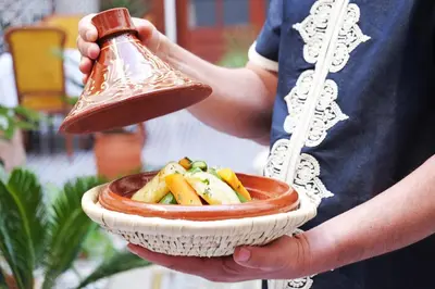 a person holding a bell and a bowl of food at Riad Alassala Fes in Fès