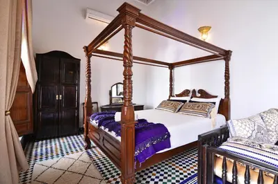 a bedroom with a four poster canopy bed at Riad Alassala Fes in Fès