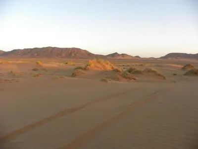 a road in the desert with mountains in the background at Sahara Luxury Camp in Zagora