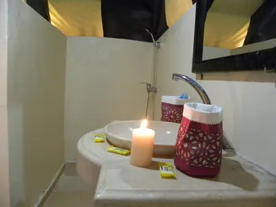 a candle on a sink in a bathroom at Sahara Luxury Camp in Zagora