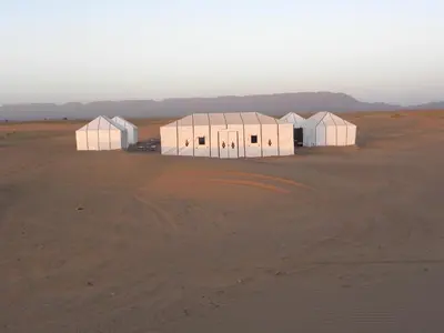 a group of white buildings in the desert at Sahara Luxury Camp in Zagora